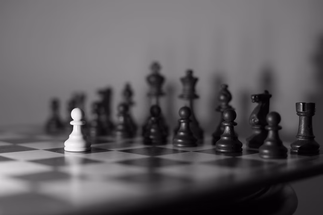 棋盤上一枚白兵面對整排黑棋，象徵單一 AI 公司面對多家巨頭的競爭格局