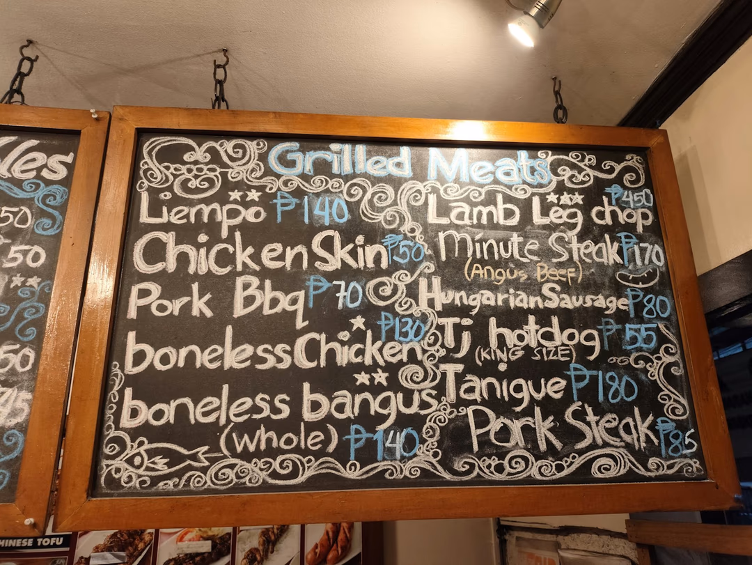 餐廳門口的黑板菜單，每一道餐點後面都清楚寫著價格