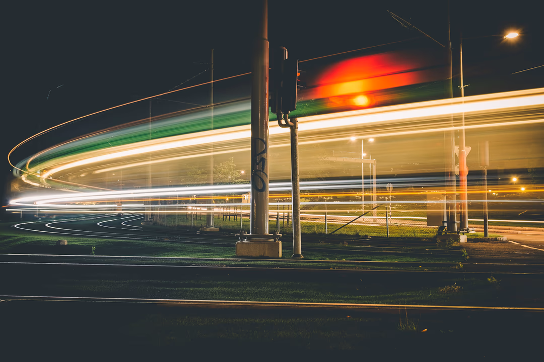 夜間長曝光下的車燈軌跡劃過馬路，象徵從對話帶出的流量終於能被追蹤出完整路徑