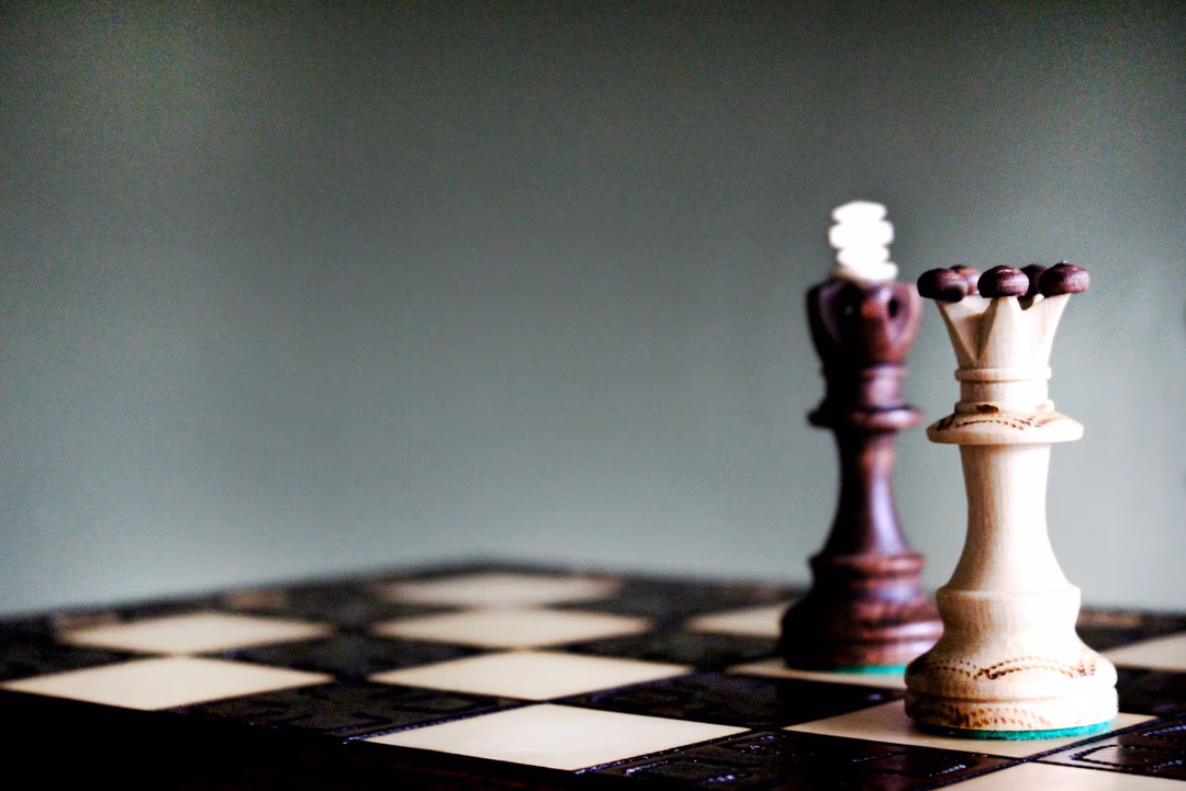 棋盤上對峙的國王與皇后棋子，象徵模型選型是一連串可調整的決策，而不是一次押注定終身